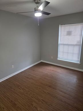 Hattiesburg apartment for rent - A room with a ceiling fan and a window with blinds.