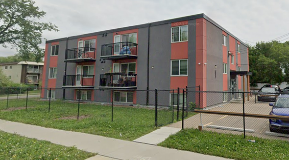 Edmonton apartment for rent - an apartment building with a chain link fence in front of it