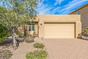 Tucson house for rent - a garage door in front of a house with a tree