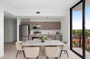 Miami apartment for rent - A modern kitchen with a table and chairs.