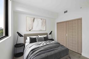 Miami apartment for rent - A bedroom with a large bed and a painting on the wall.