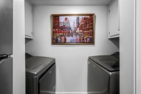 Nashville apartment for rent - A framed picture of a cityscape hangs on a wall above two dishwashers in a kitchen.