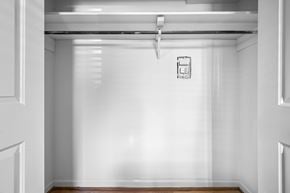 Nashville apartment for rent - A white hallway with a door on the left and a sign on the wall.