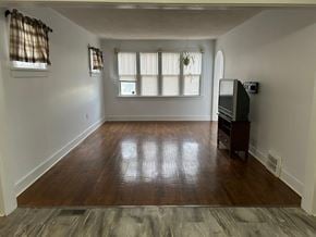 Prince Albert house for rent - an empty living room with wood floors and a tv