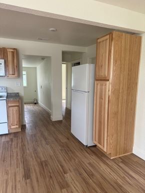 Billings house for rent - A kitchen with a white refrigerator and wooden cabinets.