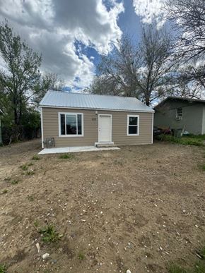 Billings house for rent - A small house with a metal roof is situated in a field.
