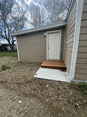 Billings house for rent - A small house with a white door and a brown mat in front of it.