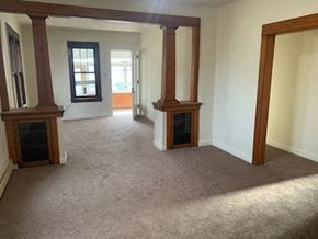 Allentown house for rent - an empty living room with pillars and a fireplace