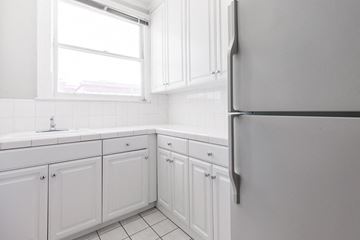 San Francisco apartment for rent - a white kitchen with white cabinets and a refrigerator