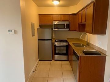 Chicago apartment for rent - A kitchen with a refrigerator, oven, microwave, and sink.