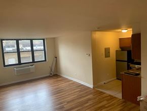 Chicago apartment for rent - A room with wooden floors and a window.