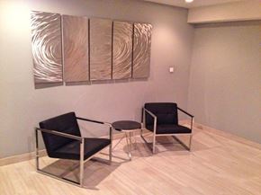 Chicago apartment for rent - Two black chairs and a table are in front of a wall with a large piece of artwork.