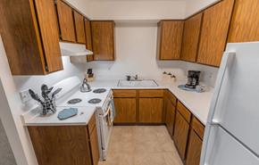 Oregon apartment for rent - a kitchen with wooden cabinets and white appliances and a refrigerator