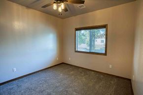 Show Low house for rent - an empty living room with a window and a ceiling fan
