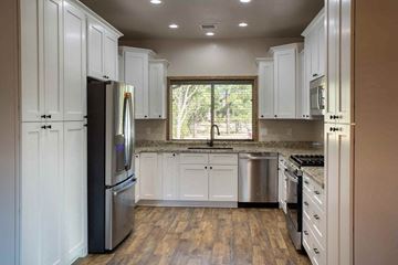 Show Low house for rent - a kitchen with white cabinets and stainless steel appliances