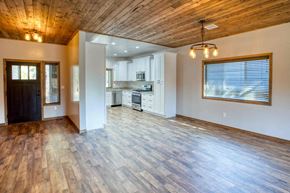 Show Low house for rent - an empty living room with a kitchen in the background