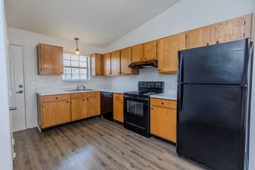 Murfreesboro apartment for rent - A kitchen with wooden cabinets and black appliances.
