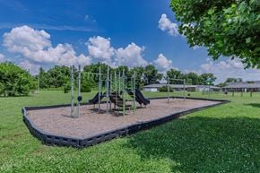 Murfreesboro apartment for rent - A playground with a slide and swings under a blue sky.