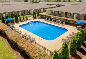 Murfreesboro apartment for rent - A swimming pool surrounded by a fence and trees.