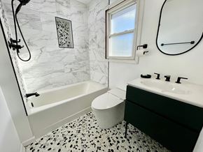 Louisville house for rent - a bathroom with black and white tile and a tub and sink