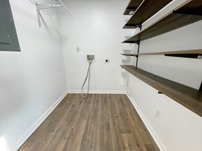 Louisville house for rent - a room with white walls and wood flooring and a white wall with a shelf