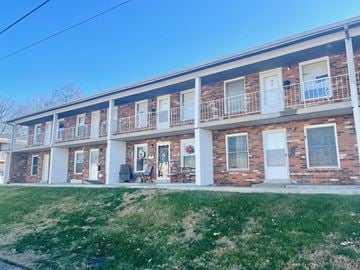 Louisville house for rent - the front of a brick apartment building with a lawn
