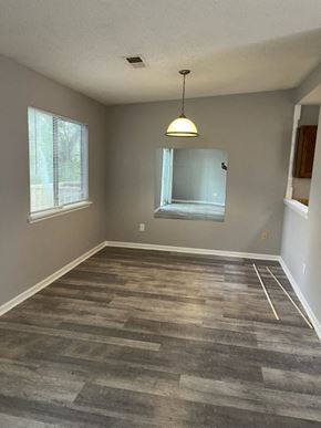 Newnan house for rent - an empty living room with a wood floor and a window