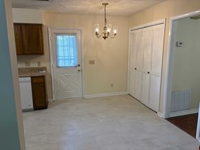 Newnan house for rent - A room with a chandelier, a door, and a window.