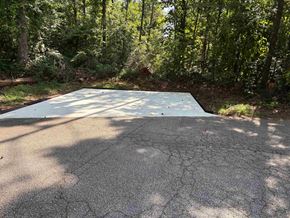 Newnan house for rent - A cracked asphalt surface with trees in the background.