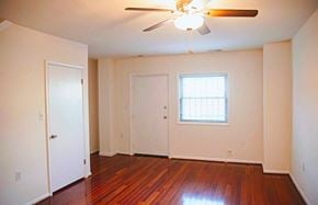 Washington apartment for rent - the living room of an empty house with wooden floors and a ceiling fan