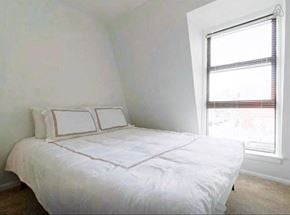 Washington apartment for rent - a small bedroom with a bed and a window