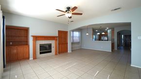 Rockwall house for rent - A spacious living room with a fireplace and a ceiling fan.