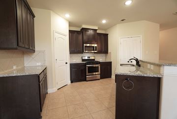 Greenville house for rent - a kitchen with dark cabinets and a counter top