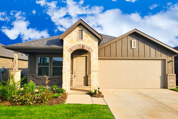 Terrell apartment for rent - A house with a stone archway entrance and a garage door.