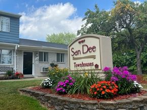 Taylor apartment for rent - A sign for San Dee Townhouses is surrounded by flowers.