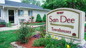 Taylor apartment for rent - A sign for San Dee Townhouses stands in front of a house.