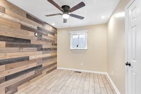 Cleveland house for rent - a living room with a wooden wall and a ceiling fan