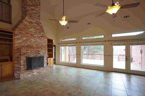 Rockwall house for rent - A living room with a fireplace and a ceiling fan.