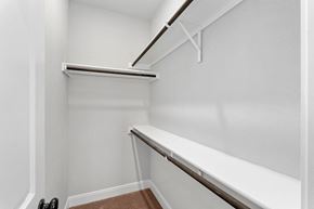 Spring Branch apartment for rent - a walk in closet with white walls and a white bench