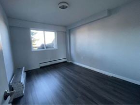 Vancouver apartment for rent - an empty room with wooden floors and a window