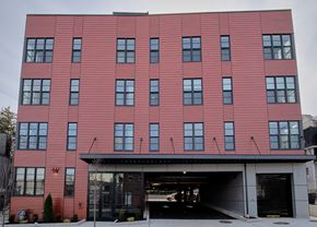 Nyack apartment for rent - A red building with a black garage door in front.