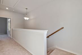 San Antonio apartment for rent - the landing of a staircase in a home with a white wall and a stair railing