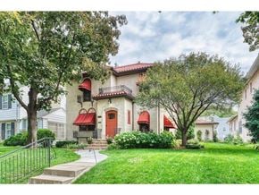 Minneapolis house for rent - a home with a red door and a lawn and trees