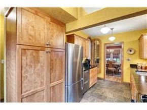 Minneapolis house for rent - a kitchen with wooden cabinets and a stainless steel refrigerator