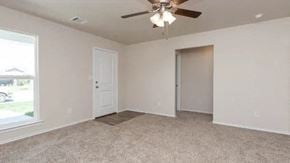 Odessa house for rent - an empty living room with a ceiling fan and a door
