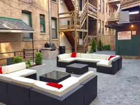Chicago apartment for rent - A patio with black and white furniture and a red cushion.