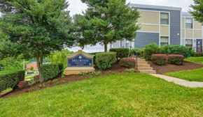 Capitol Heights townhouse for rent - a building with a sign in front of a lawn and trees