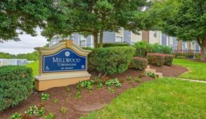 Capitol Heights townhouse for rent - a sign for millwood townhomes in front of trees and bushes