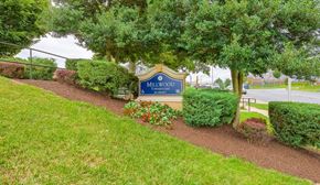 Capitol Heights townhouse for rent - a sign in front of a park with trees and bushes