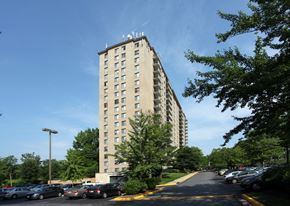 Rockville apartment for rent - A tall building with a parking lot in front of it.